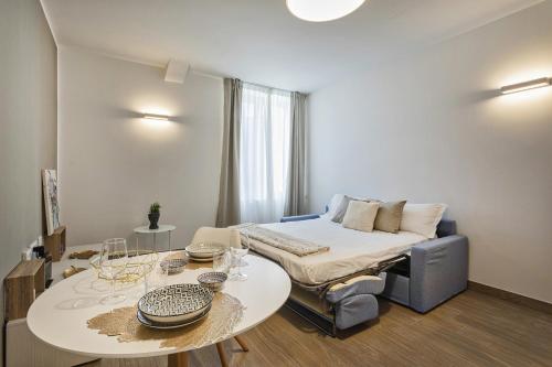 een kleine kamer met een bed, een tafel en een bank bij Comfort studio in Brignole de Ferrari by Wonderful Italy in Genua