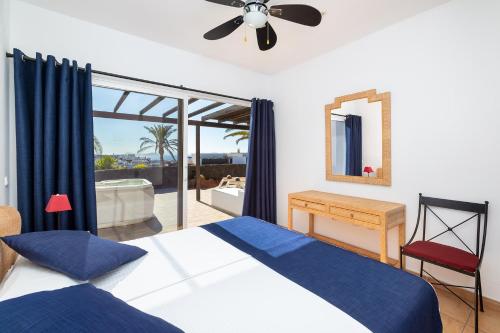 Schlafzimmer mit einem Bett und einem Deckenventilator in der Unterkunft Dreamplace Bocayna Village in Playa Blanca