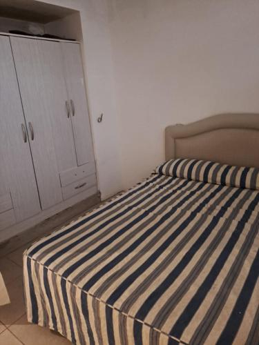 1 dormitorio con 1 cama con manta de rayas azul y blanco en Santa fe 1664 en Mar del Plata