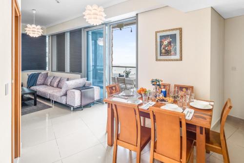 a dining room and living room with a table and chairs at Breathtaking sea-view condo in Dubai Marina - Palm Views! in Dubai