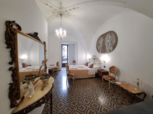 a large room with two beds and a mirror at Terra d'Amuri Hotel in Catania