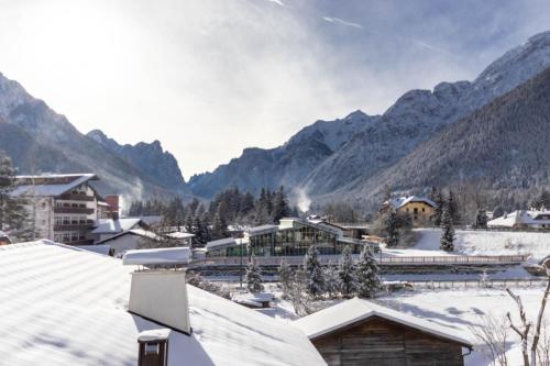 a snow covered village with mountains in the background at Casa Flora in Dobbiaco