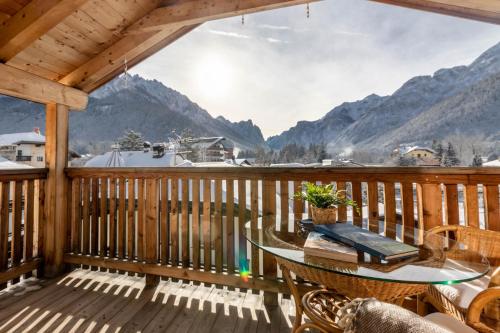 a balcony with a table and a view of mountains at Casa Flora in Dobbiaco