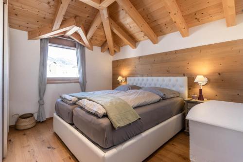 una camera con letto e soffitto in legno di Casa Flora a Dobbiaco