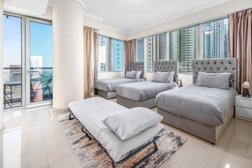 two beds in a room with large windows at Breathtaking sea-view condo in Dubai Marina - Palm Views! in Dubai