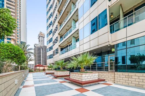 a sidewalk in front of a tall building at Breathtaking sea-view condo in Dubai Marina - Palm Views! in Dubai