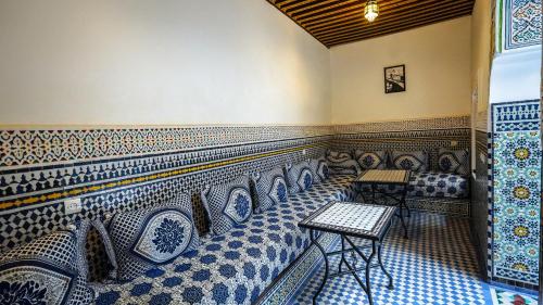 a room with blue and white patterned seats in a restaurant at Riad Green House in Fès