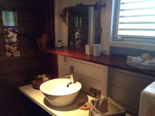 La salle de bains est pourvue d'un lavabo blanc sur un comptoir. dans l'établissement Charmant Bungalow Un p'tit coin de paradis, à Saint-François