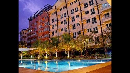 a large building with a swimming pool in front of it at Rochester Condo in Manila