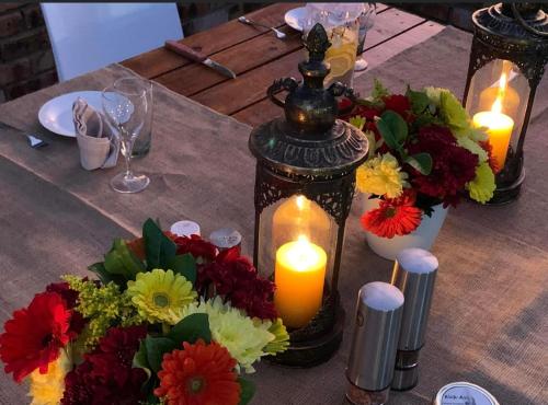 a table with candles and flowers on a table at Modjadji Estate Lodge & Spa in Grietjie Nature Reserve