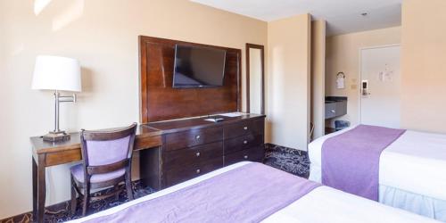 a hotel room with a desk with a tv and a bed at Red Garter Hotel & Casino by Red Lion Hotels in West Wendover