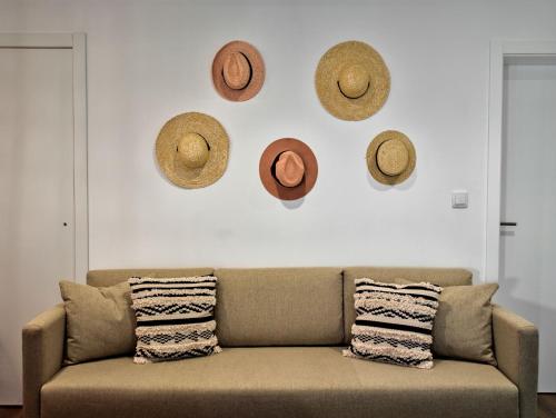 uma sala de estar com um sofá e chapéus na parede em The Bastion Elvas Apartments em Elvas