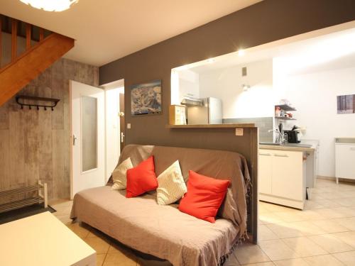 - un salon avec un canapé et des oreillers rouges dans l'établissement Beau Duplex T3 avec Balcon, Wifi et Parking à 300m du Centre - FR-1-608-16, à Le Mont-Dore