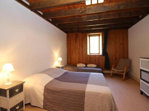 une chambre avec un grand lit et une fenêtre dans l'établissement Beau Duplex T3 avec Balcon, Wifi et Parking à 300m du Centre - FR-1-608-16, à Le Mont-Dore