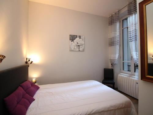 um quarto com uma cama branca e uma janela em Appartement Mont-Dore, 3 pièces, 6 personnes - FR-1-608-23 em Le Mont-Dore
