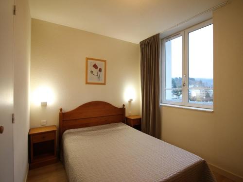 a bedroom with a bed and a large window at Appartement La Bourboule, 2 pièces, 5 personnes - FR-1-608-29 in La Bourboule