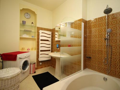 La salle de bains est pourvue d'une baignoire, d'un lavabo et d'un lave-linge. dans l'établissement T2 La Bourboule Centre avec Wifi, 100m des Thermes, Jusqu'à 6 Pers. - FR-1-608-19, à La Bourboule