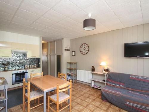 un salon avec une table et un canapé dans l'établissement Beau T3 au Mont-Dore proche Thermes et Parc - FR-1-608-21, à Le Mont-Dore