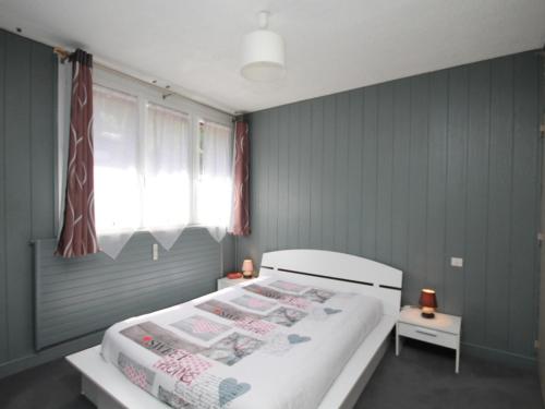 une chambre avec un grand lit blanc avec des murs bleus dans l'établissement Beau T3 au Mont-Dore proche Thermes et Parc - FR-1-608-21, à Le Mont-Dore