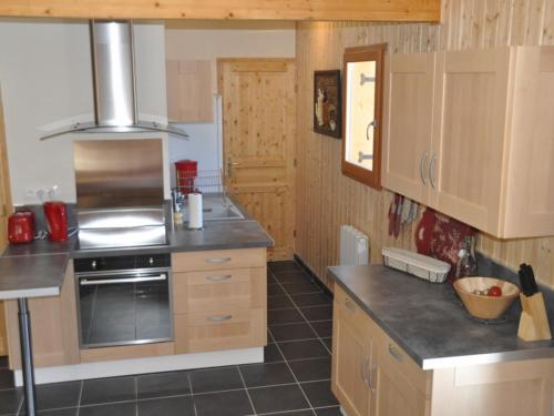 a kitchen with wooden cabinets and a stove top oven at Chalet 4* avec WIFI au Mont-Dore - FR-1-608-31 in Le Mont-Dore