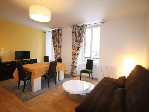 un salon avec une table et un canapé dans l'établissement Charmant T3 rénové au centre du Mont-Dore avec Wi-Fi, proche thermes et marché. - FR-1-608-22, à Le Mont-Dore