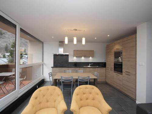 une cuisine et une salle à manger avec une table et des chaises dans l'établissement Splendide T3 avec Terrasse et Garage au Mont-Dore, Idéalement Situé Proche Thermes - FR-1-608-24, à Le Mont-Dore