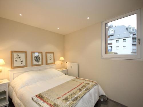 une chambre avec un lit et une fenêtre dans l'établissement Splendide T3 avec Terrasse et Garage au Mont-Dore, Idéalement Situé Proche Thermes - FR-1-608-24, à Le Mont-Dore