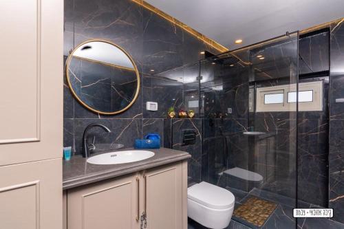 a bathroom with a sink and a shower with a mirror at שקיעה בים - דירות יוקרתיות מהממות עם ג'קוזי ונוף לים יש מקלט in Haifa