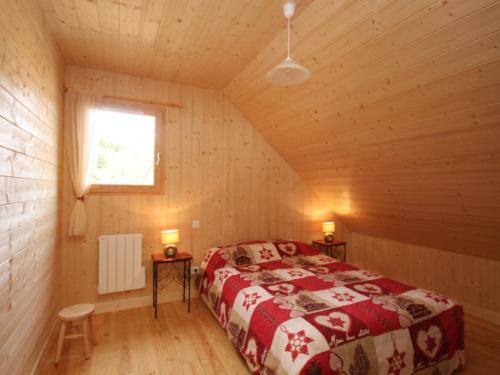 a bedroom in a log cabin with a bed and a window at Chalet au Mont-Dore avec terrasse, 2 ch., navette ski, prox. centre & sentiers - FR-1-608-41 in Le Mont-Dore