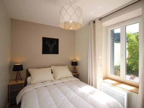 ein Schlafzimmer mit großem Bett und Fenster in der Unterkunft Appartement T3 avec Jardin Privatif et WIFI à Mont-Dore, Rénové, Parking et Garage Inclus - FR-1-608-37 in Le Mont-Dore