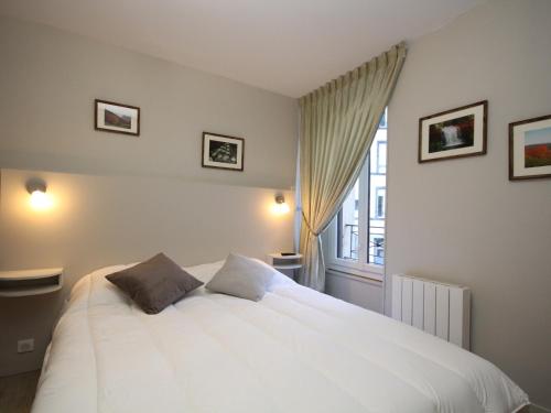 ein Schlafzimmer mit einem großen weißen Bett und einem Fenster in der Unterkunft Le Mont-Dore - Charmant T3 en plein centre-ville avec accès WiFi, proche thermes et commodités - FR-1-608-28 in Le Mont-Dore