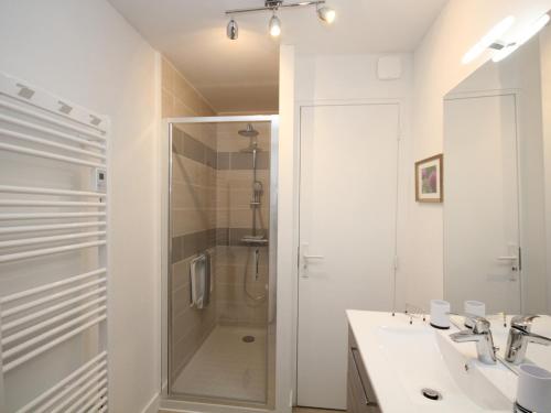 uma casa de banho branca com um chuveiro e um lavatório. em Appartement Mont-Dore, 3 pièces, 6 personnes - FR-1-608-28 em Le Mont-Dore