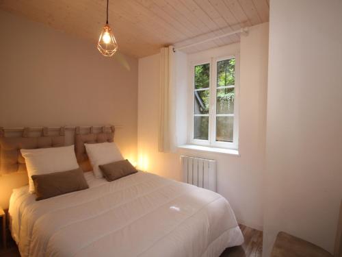a bedroom with a white bed and a window at Appartement Mont-Dore, 3 pièces, 5 personnes - FR-1-608-40 in Le Mont-Dore