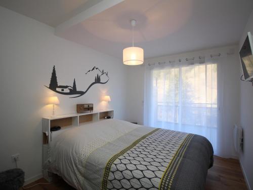 ein Schlafzimmer mit einem Bett mit einem Schild an der Wand in der Unterkunft Mont-Dore : Somptueux T2 avec WIFI, terrasse et parking - FR-1-608-45 in Le Mont-Dore