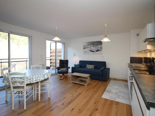 un salon avec une table et un canapé bleu dans l'établissement Mont-Dore : Somptueux T2 avec WIFI, terrasse et parking - FR-1-608-45, à Le Mont-Dore