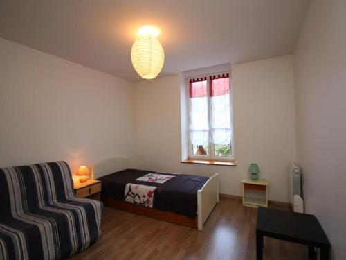 une chambre avec un lit, une table et une fenêtre dans l'établissement T3 au Mont-Dore avec wifi, proche centre, idéal familles, 5 pers, 2 chambres - FR-1-608-35, à Le Mont-Dore