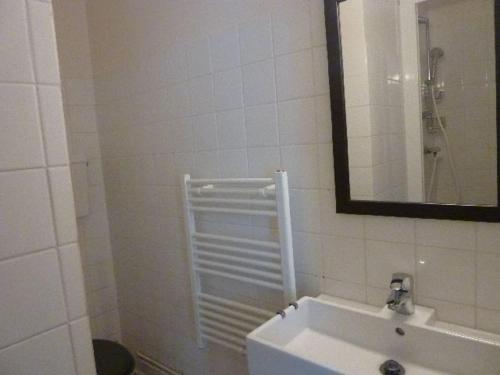 une salle de bain blanche avec un lavabo et un miroir dans l'établissement Charmant T1 au Mont-Dore, balcon, hyper centre, bien équipé, max 4 pers. - FR-1-608-38, à Le Mont-Dore