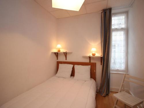 - une chambre avec un lit avec deux oreillers et une fenêtre dans l'établissement Lumineux T4 à La Bourboule, 6 pers, proche centre, tout équipé, cour privée, 68m² - FR-1-608-39, à La Bourboule
