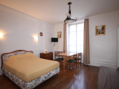 une chambre avec un lit, une table et une fenêtre dans l'établissement Appartement T1 avec ascenseur au centre de Mont-Dore pour 4 personnes, non accessible PMR - FR-1-608-60, à Le Mont-Dore