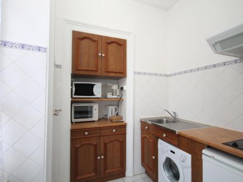 une cuisine avec un évier et un micro-ondes dans l'établissement Appartement T1 avec ascenseur au centre de Mont-Dore pour 4 personnes, non accessible PMR - FR-1-608-60, à Le Mont-Dore