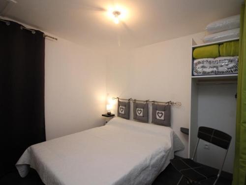 une chambre avec un lit blanc dans une pièce dans l'établissement Bel Appartement T3 avec WIFI au Centre du Mont-Dore, Proche des Thermes - FR-1-608-49, à Le Mont-Dore