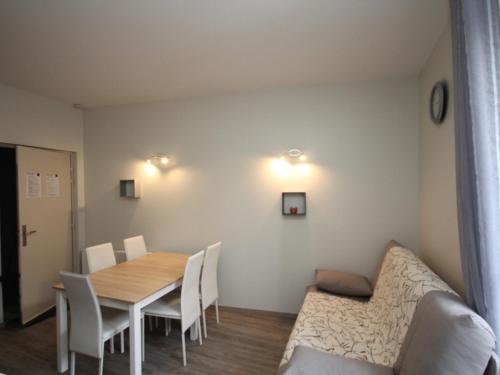 une salle à manger avec une table, des chaises et un canapé dans l'établissement Appartement T2 Central avec Ascenseur et WIFI au Mont-Dore - FR-1-608-63, à Le Mont-Dore