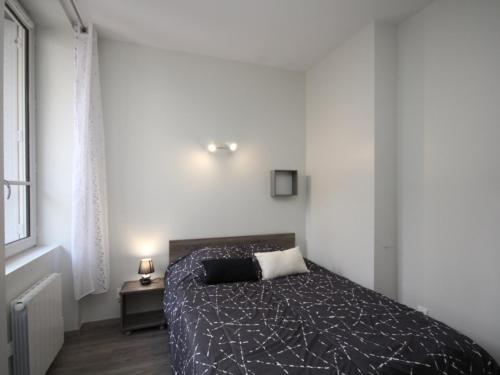 une chambre avec un lit dans une pièce blanche dans l'établissement Appartement T2 Central avec Ascenseur et WIFI au Mont-Dore - FR-1-608-63, à Le Mont-Dore