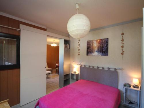 une chambre avec un lit avec une couverture rose dans l'établissement Mont-Dore : T2 avec balcon et WIFI - FR-1-608-58, à Le Mont-Dore