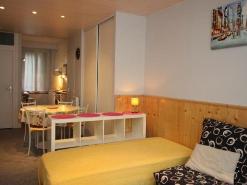 Cette chambre comprend un lit, une table et une cuisine. dans l'établissement Studio confort avec wifi, hyper centre Mont-Dore, proche Thermes - FR-1-608-74, à Le Mont-Dore