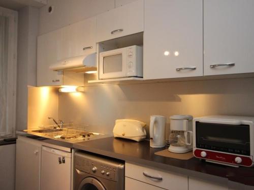 une cuisine avec un comptoir avec un micro-ondes dans l'établissement Studio confort avec wifi, hyper centre Mont-Dore, proche Thermes - FR-1-608-74, à Le Mont-Dore