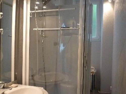 une salle de bain avec une douche avec une porte vitrée dans l'établissement Studio confort avec wifi, hyper centre Mont-Dore, proche Thermes - FR-1-608-74, à Le Mont-Dore