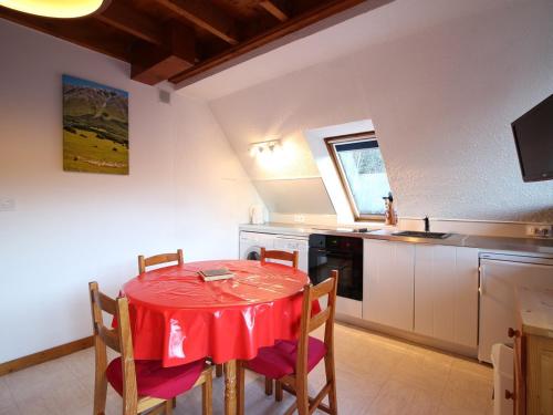 - une cuisine avec une table et des chaises rouges dans la chambre dans l'établissement Appartement Duplex T3 avec Terrasse, Parking, WiFi - FR-1-608-72, à Le Mont-Dore