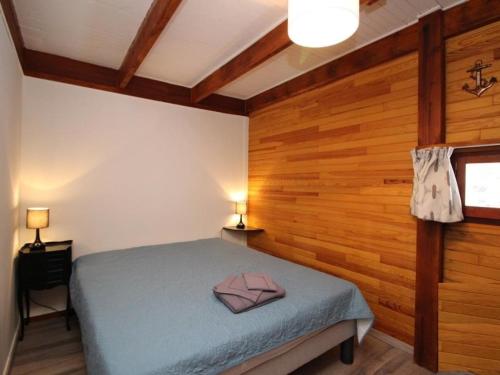 1 dormitorio con 1 cama en una habitación con paredes de madera en Chalet Mont-Dore, 4 pièces, 9 personnes - FR-1-608-88 en Le Mont-Dore