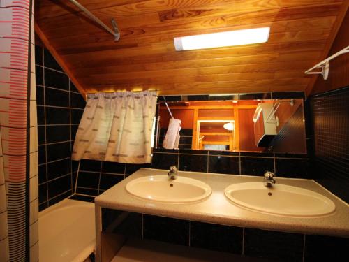 a bathroom with two sinks and a bath tub at Mont-Dore : Chalet agréable avec WIFI pour 9 personnes - FR-1-608-88 in Le Mont-Dore